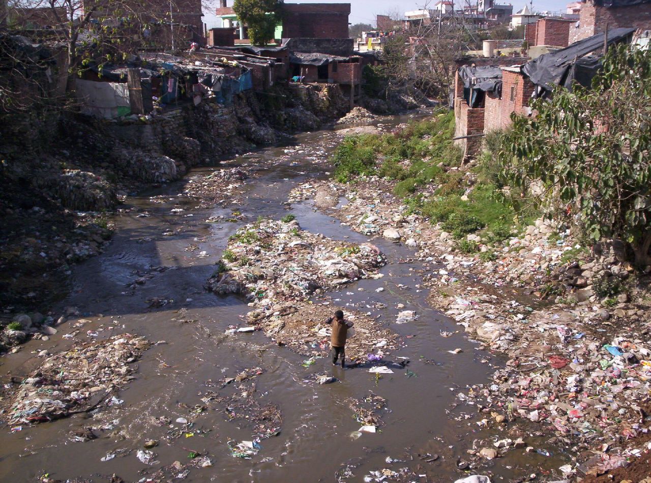 A child walks in a trash-laden river in the Indian Himalayas